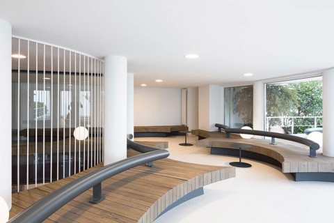 Modern interior in club with curved wooden benches and sleek iron railings. Minimalistic design