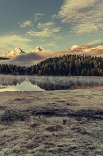 Lake Staz near Sankt Moritz in the Engadin in Switzerland. Morning atmosphere with fog in autumn.