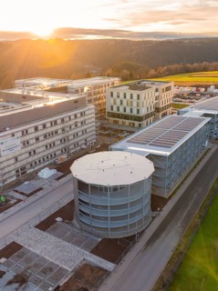Modern industrial plant with main buildings and nature in the background, new Calw health campus,