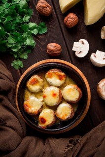 Traditional Georgian dish, appetizer, stuffed mushrooms, Sulguni cheese, baked in a Ketzi clay pan,