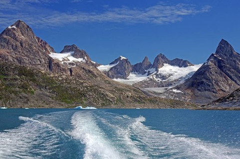 Bow wave a boat of snow-covered mountains in a clear fjord, Tasilaq, Arctic, Greenland, Denmark