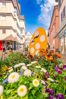 Springtime floral decoration with orange egg in a busy urban environment, Nagold, Calw district,