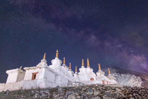 Under a mesmerizing starry sky in Diskit, Nubra Valley, India, ancient white stupas stand