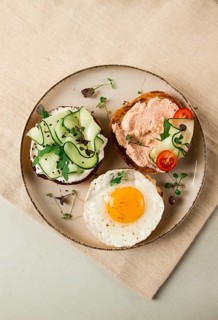 Assortment of sandwiches, white bread, fried egg, cream cheese and cucumber, capelin caviar, sesame