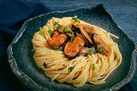 Spaghetti with mussels, without shell, pasta with peeled mussels, in carbonara sauce, micro-greens,