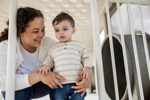 A joyful mother spends quality time with her baby in a sunlit park. They enjoy togetherness,