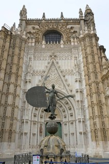 Impressive Gothic façade with a bronze statue of King John in front of the cathedral, Seville,