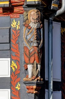 Decorated wooden figure on a half-timbered house, shows Renaissance elements with bright colours