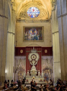 Church altar with impressive vault and colorful stained-glass window in Gothic style, Seville,