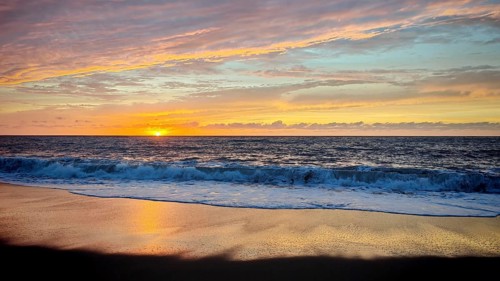 A bright sunset spreads warm colors over the sea and ends at the horizon, hiking, Tarrafal de Monte