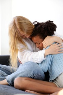 A warm and heartfelt embrace between two people, capturing a moment of comfort and support. The