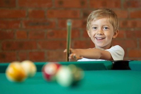 5-6 years old boy playing billiard