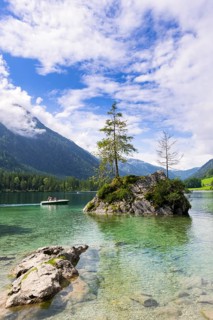 Hintersee near Ramsau with clear green water, surrounded by forests and mountains under a cloudy