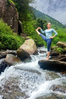 Yoga outdoors, woman doing Ashtanga Vinyasa Yoga balance asana Utthita Hasta Padangushthasana,
