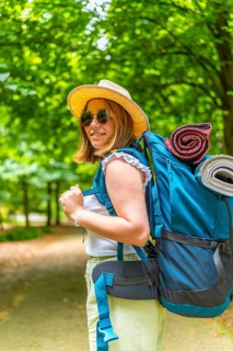 Vertical portrait of a caucasian active women turning to smile at camera while enjoying the forest