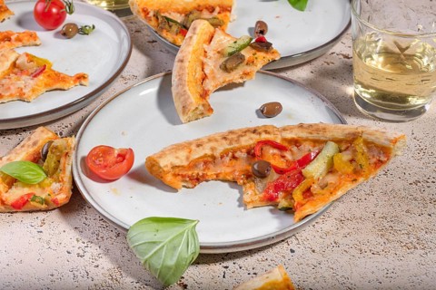 Slices of mouthwatering vegetarian pizza topped with vibrant bell peppers, ripe tomatoes, and fresh