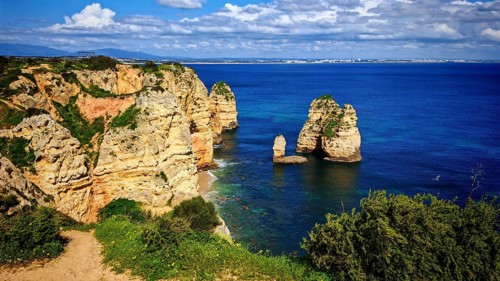 Coastal landscape with distinctive rock formations, rock arch and wide views of the ocean, Lagos,