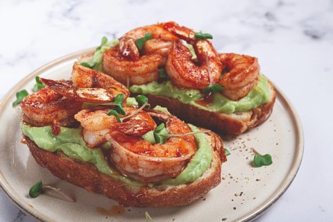 Sandwiches with avocado and caramelized shrimp, micro-greens, breakfast, on a plate, top view,