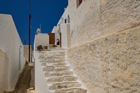 Stone staircase between white houses under clear blue sky, Megalo Chorio, Zero Waste Island, Tilos,