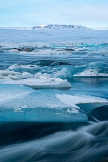 Tranquil beauty of blue icebergs resting on the black sands of Diamond Beach, Iceland. The winter