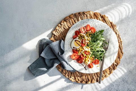 A nutritious keto lunch featuring boiled eggs, fresh rocket, cherry tomatoes, green peas, and