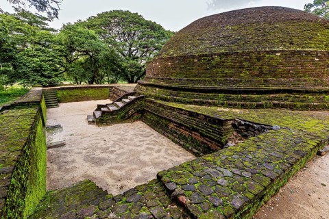 Ancient stupa covered with moss, showing traces of the past, temple ruins near Sigiriya in Sri
