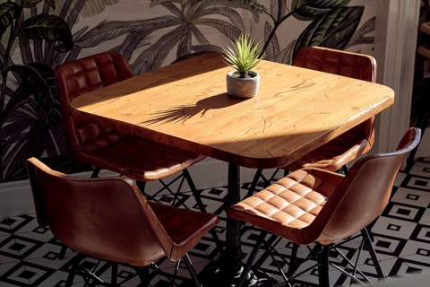 A chic restaurant interior featuring a polished wooden table and two leather chairs, complemented