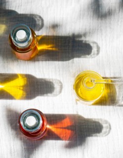Overhead view of natural body oils infused with plants like calendula and rose. The image captures