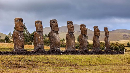 Several Moai statues on a grassy hill against a mountainous backdrop, The Moai statues on Easter