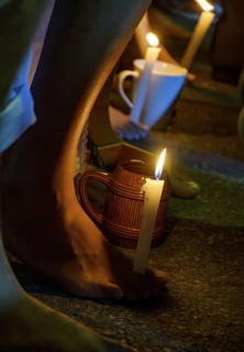 Feet holding a candle during prayer in a typical Umbanda ceremony, Brazil