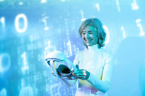 An elderly Asian woman interacts with virtual reality technology, showcasing the possibilities of