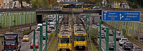 Lots of traffic on the A 40 motorway on four lanes and two subways on two lanes and a bus on the