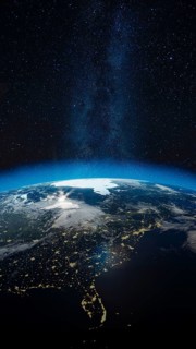 This stunning view showcases Earth illuminated by city lights under a blanket of stars, revealing a