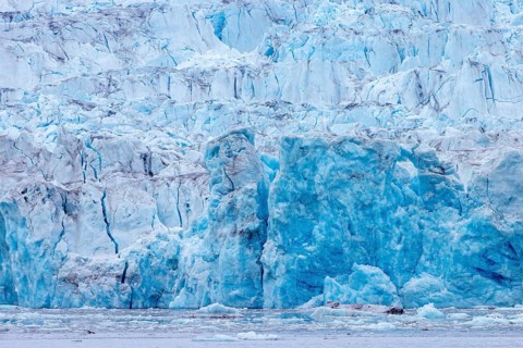 Calving ice wall of Kongsbreen, marine-terminating glacier debouching into Kongsfjorden in summer,
