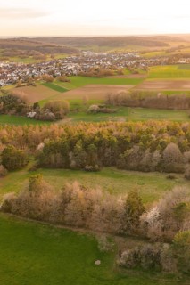 View over meadows and forests to a nearby town in the evening light, e-bike tour, old sports ground