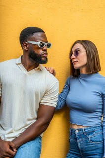 Vertical photo of a cool modern stylish multi-ethnic couple with denim clothes and futuristic