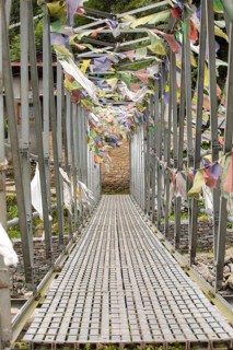 A suspension bridge on the Everest Trek is beautifully adorned with colorful prayer flags. These