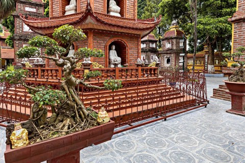 Detail of a pagoda with bonsai trees and ancient architecture in a Buddhist temple complex, The