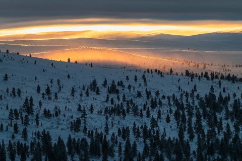 Lighting over snow-covered mountain ranges, Urho Kekkonen National Park, Lapland, Finland, January