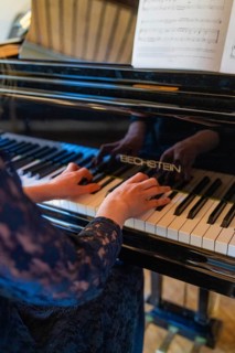 Hands of a person playing a Bechstein piano with a score in the background, Jugend Musiziert,