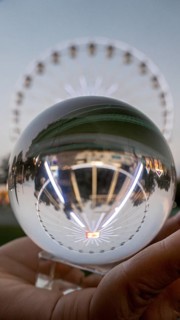 Cropped unrecognizable person's hand holding a crystal sphere looking through the Chicago Ferris