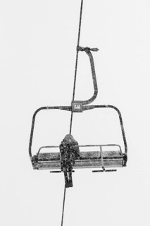 Skier on the ski lift sofa during cold day
