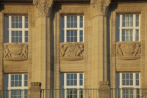 House façade with reliefs and columns with channels, detail, yellow sandstone,