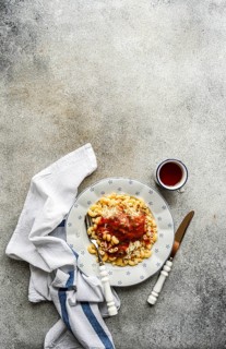 A plate of delicious chifferi rigati pasta topped with rich tomato sauce and cheese. Served on a