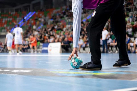 Handball goalkeeper raises ball during the match