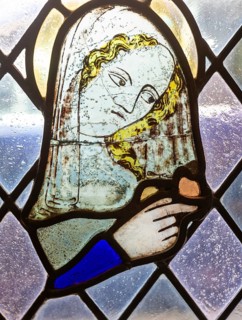 Stained glass window depiction of medieval woman face, Bristol cathedral church, Bristol, England,