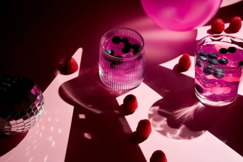 A vibrant scene with refreshing pink drinks in glasses with blueberries and raspberries. The pink