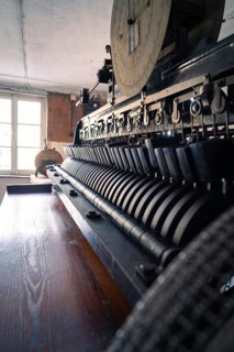Old industrial machine with complex wheels and levers in a dimly lit room, Calw Tannery Museum,