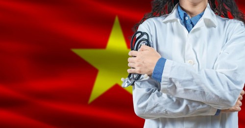 Healthcare professional with Vietnam flag background. Professional doctor holding stethoscope on