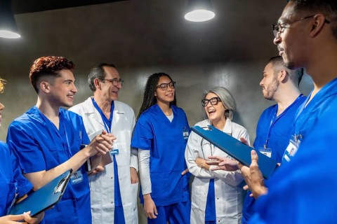 Diverse group of healthcare professionals laughing and discussing during a break, depicting